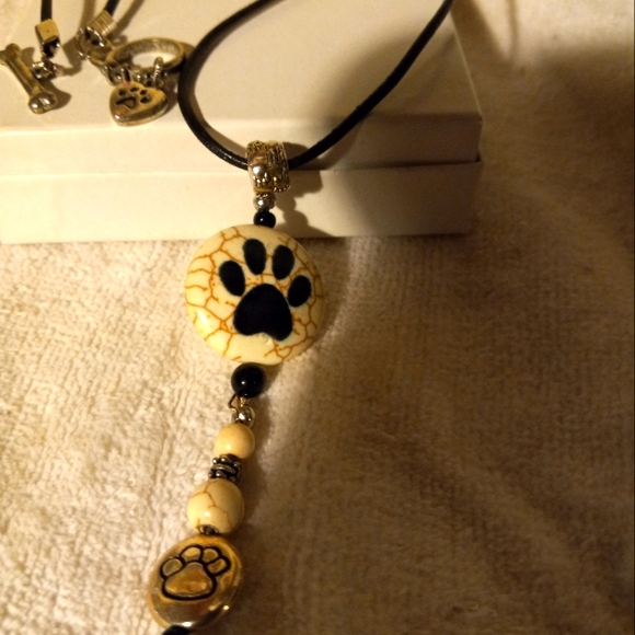 Handmade black leather cording necklace with cream bead with 🐾 print design. - Picture 1 of 4
